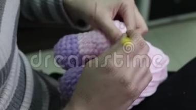 人和针线活的概念-女人用钩针编织粉红纱编织
